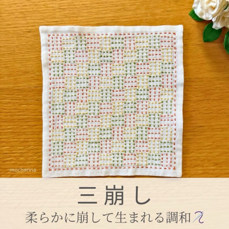 三崩し模様を刺したセリアの刺し子ふきん。3本線を崩した模様を、緑・橙・黄色の糸で縫った伝統柄の完成写真。