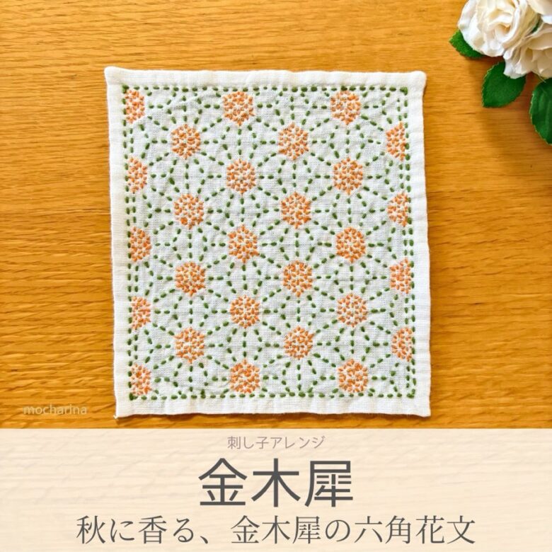 金木犀の模様を刺したセリアの刺し子ふきん。緑の葉の中心にあるオレンジの金木犀が美しい六角花文から生まれた伝統柄の完成写真。