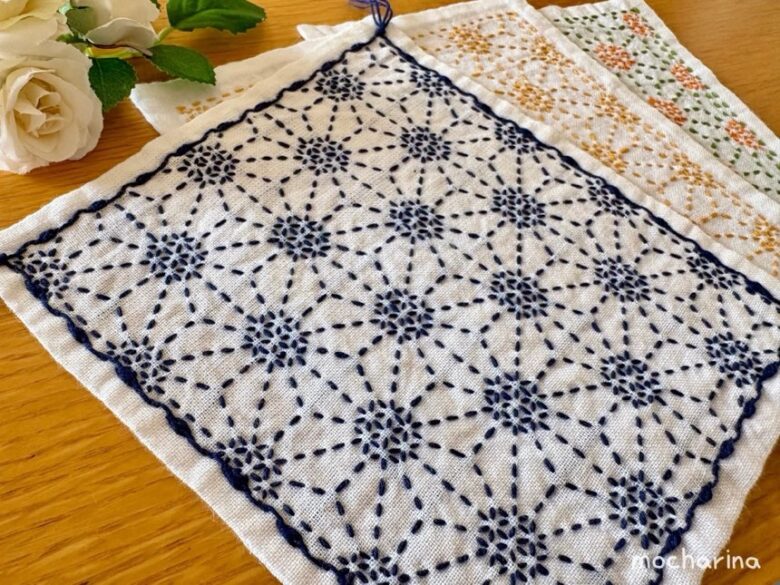 刺し子ふきん「六角花文」を斜めから撮った写真。色違いの3枚のふきんが並ぶ様子。