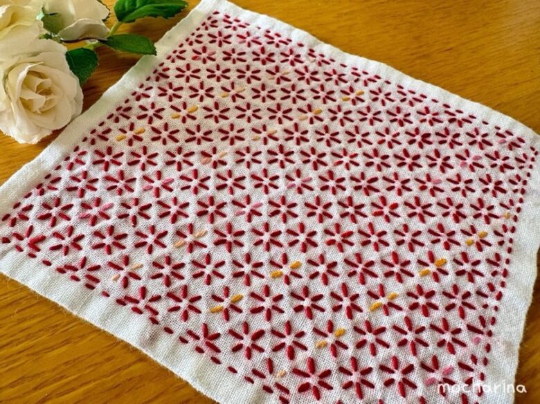 刺し子ふきん「小花刺し」を斜め撮りした完成写真。色違いのふきんを2枚並べた様子。