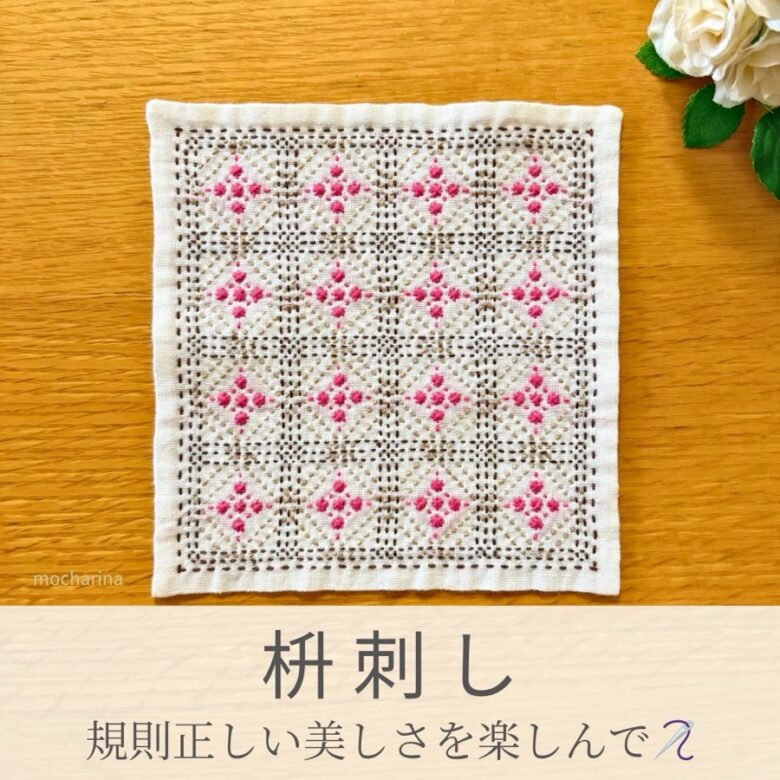 枡刺し模様を刺したセリアの刺し子ふきん。枡目にピンクの小花が咲く上品で美しい伝統柄の完成写真。