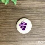 包みボタン「ぶどう」の完成写真。ボタンにぶどうの刺繡をしたデザイン。