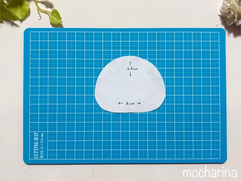 カッティングマットに型紙が乗っている写真。丸みを帯びた三角のクラゲの型紙。