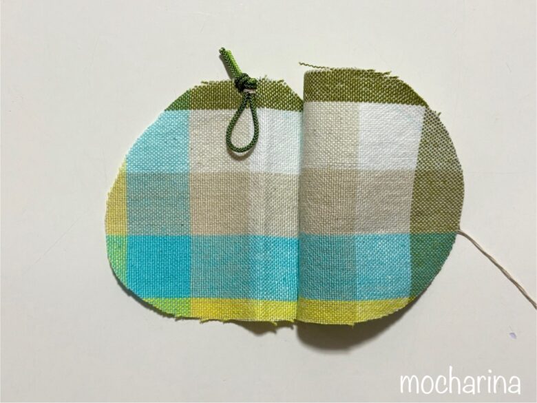 布2枚を中表に合わせて少し開いた写真。１枚の布に輪っか状の紐を縫いつけた様子。