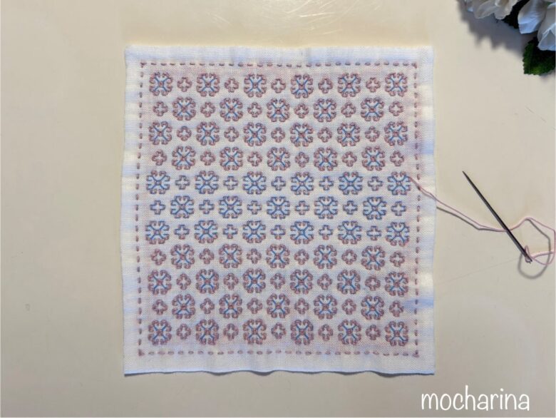 マーガレットの刺し子模様の横線を縫っている途中写真。横線を縫った部分と縫っていない部分の、比較。花の輪郭ができている様子。