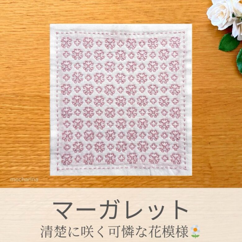 マーガレット模様を刺したセリアの刺し子ふきん。ピンクの小花が咲いた可憐な花模様の伝統柄の完成写真。