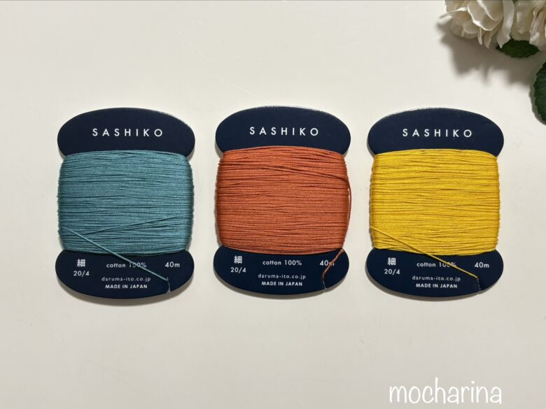 ダルマの刺し子糸の細糸、3種類の写真。青緑・オレンジ・黄色の刺し子糸が並んでいる様子。