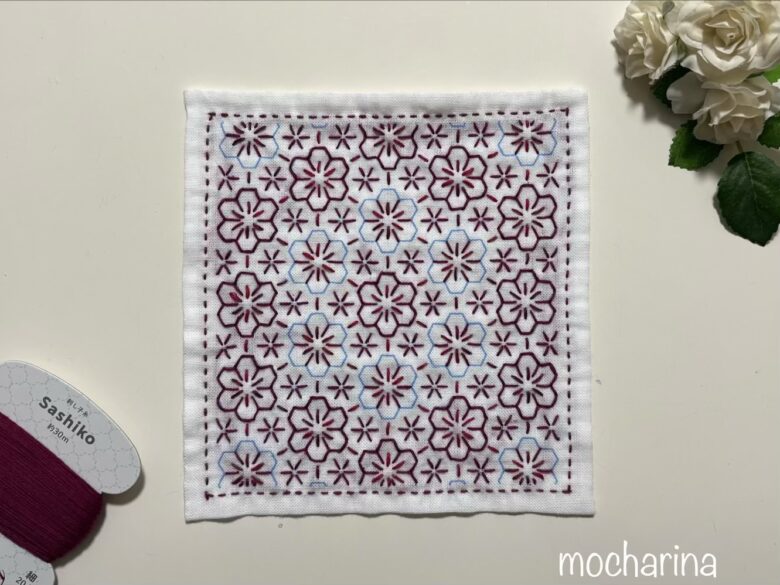 花紋様の花の輪郭を縫っている途中写真。縫い終わった花模様がとても華やかな様子。