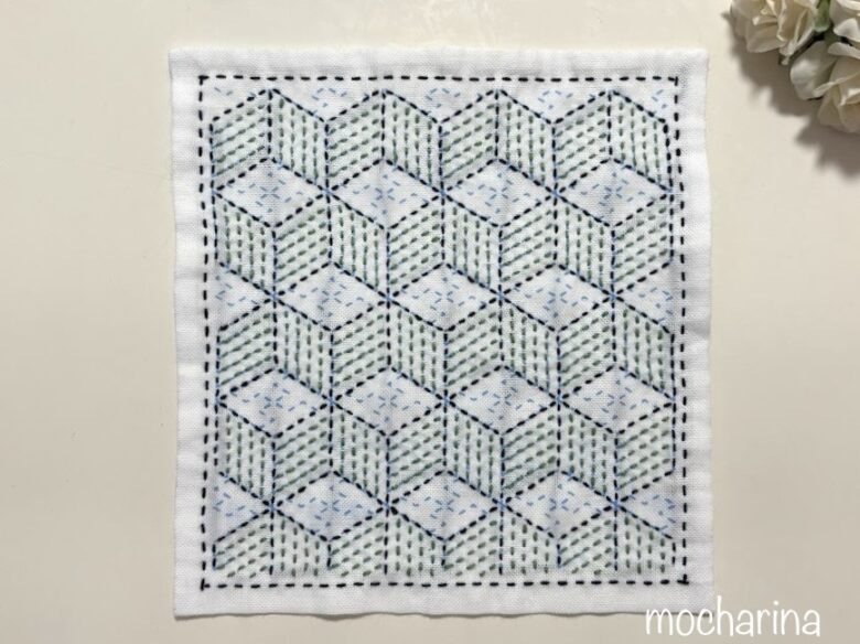 綾杉の模様を縫った写真。立方体の箱の模様を緑色で縫った様子。