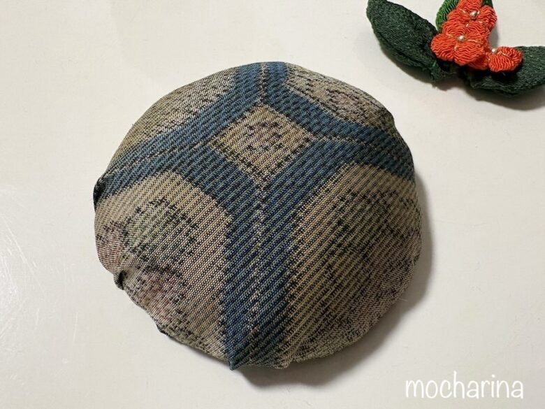 平べったい丸型の土台の写真。土台にちりめんの金木犀が添えられている様子。