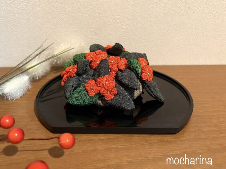 つるし飾り「金木犀」を黒いお盆に載せた写真。