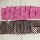 パッチワークのパフキルトのパーツを作った写真。ピンクと茶色の四角い布にタックを入れた様子。