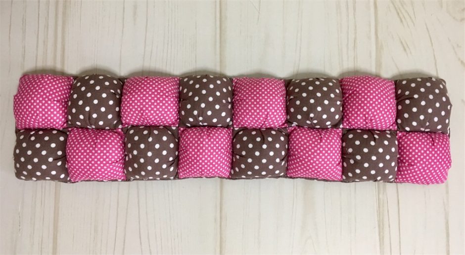 ピンクと茶色のパフクッションの写真。2色が交互に2列に並んだ様子。