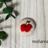 包みボタン「りんご」の完成写真。ボタンにりんごの刺繡をしたデザイン。